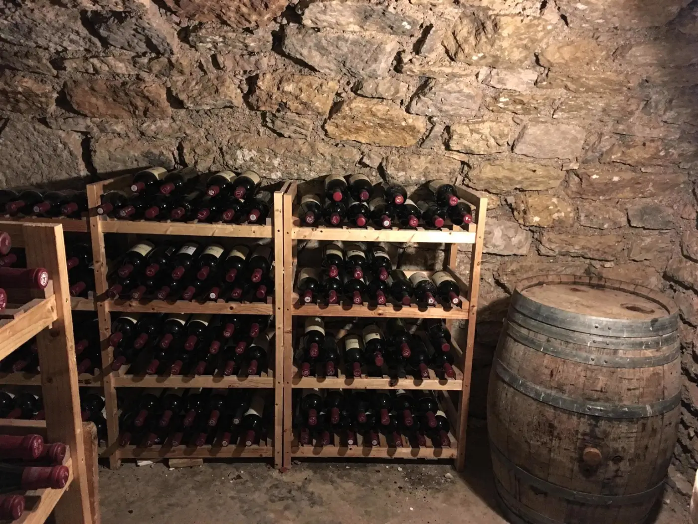 Cave à vin avec casiers en bois et bouteilles de vin rouge, illustration pour la vente de vin en ligne à Ampuis
